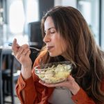Persona de 45 años comiendo ensalada saludable rica en verduras para aumentar la longevidad