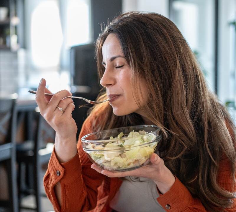 Persona de 45 años comiendo ensalada saludable rica en verduras para aumentar la longevidad