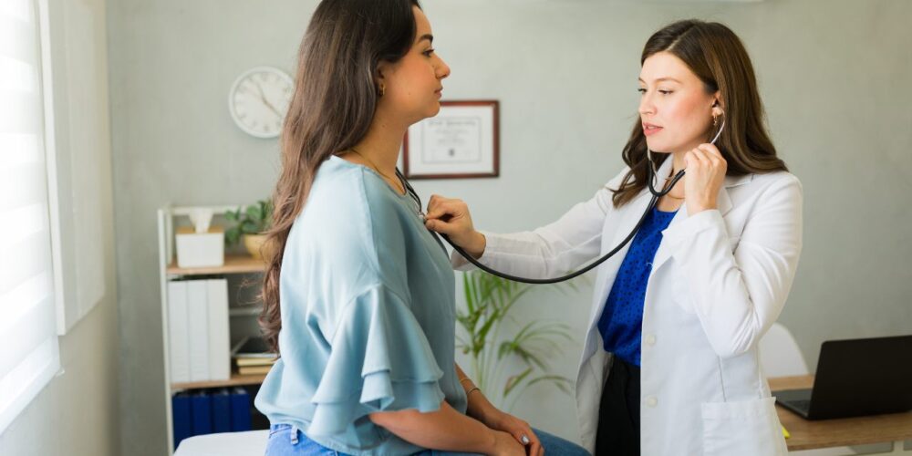 Mujer con preocupación por síntomas cardíacos explicados por un profesional sanitario