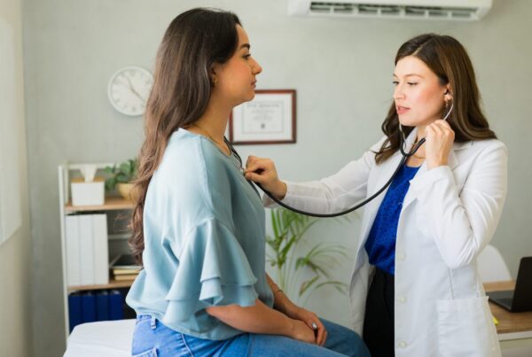 Mujer con preocupación por síntomas cardíacos explicados por un profesional sanitario