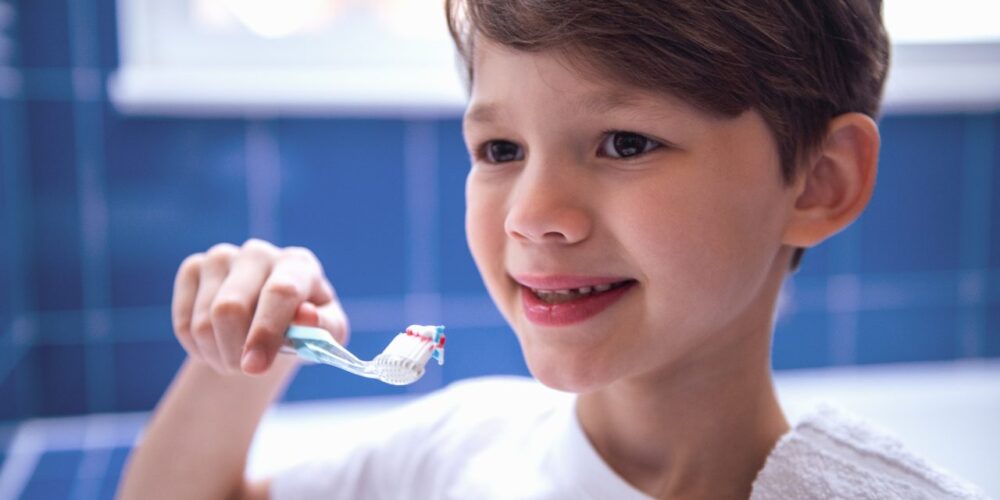 Niño cepillándose los dientes con buena salud dental