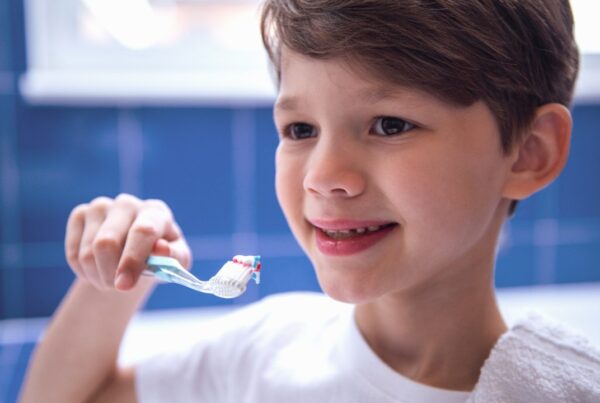 Niño cepillándose los dientes con buena salud dental