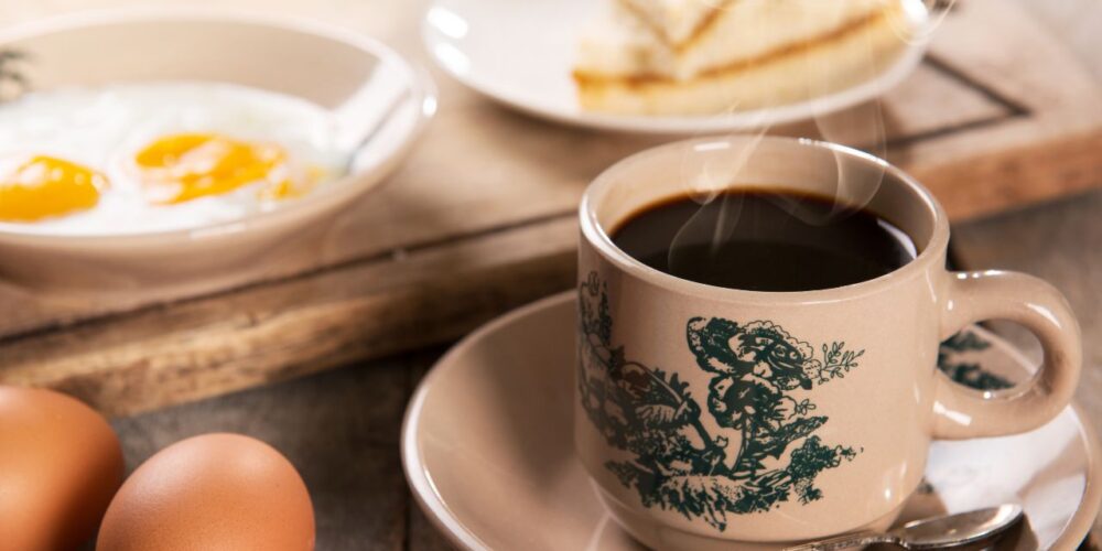Taza de café humeante sobre una mesa, asociada con salud cerebral y memoria