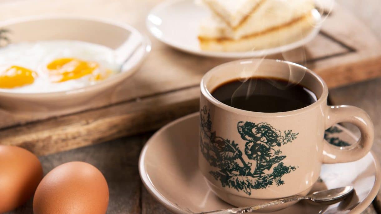 Taza de café humeante sobre una mesa, asociada con salud cerebral y memoria