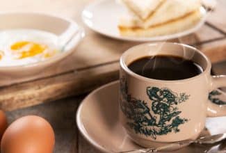 Taza de café humeante sobre una mesa, asociada con salud cerebral y memoria