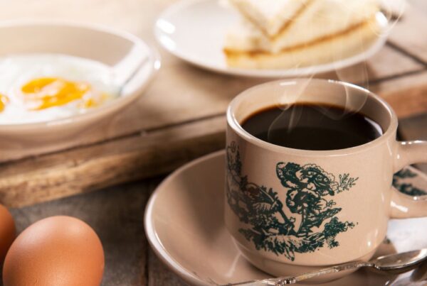 Taza de café humeante sobre una mesa, asociada con salud cerebral y memoria