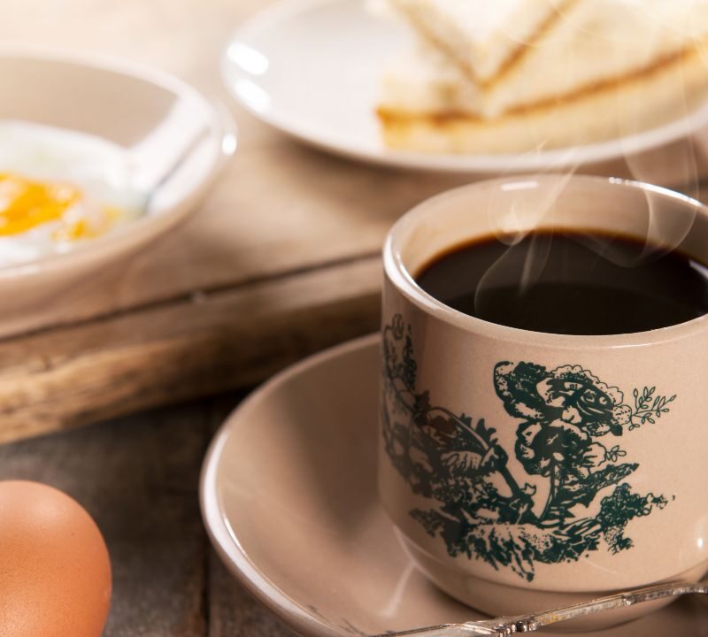 Taza de café humeante sobre una mesa, asociada con salud cerebral y memoria