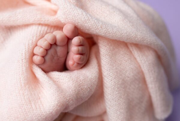 pies de recién nacido envueltos en manta simbolizando cuidado y protección