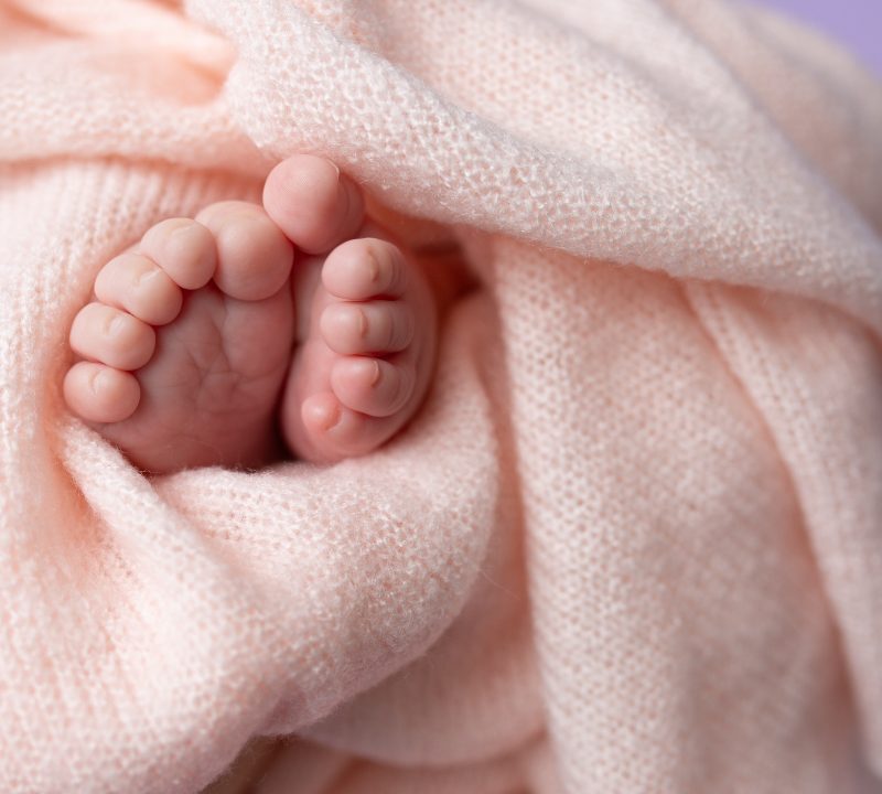 pies de recién nacido envueltos en manta simbolizando cuidado y protección
