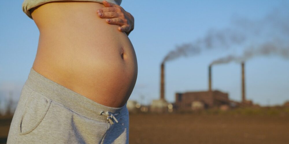 Mujer embarazada en ciudad contaminada