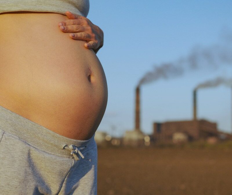 Mujer embarazada en ciudad contaminada