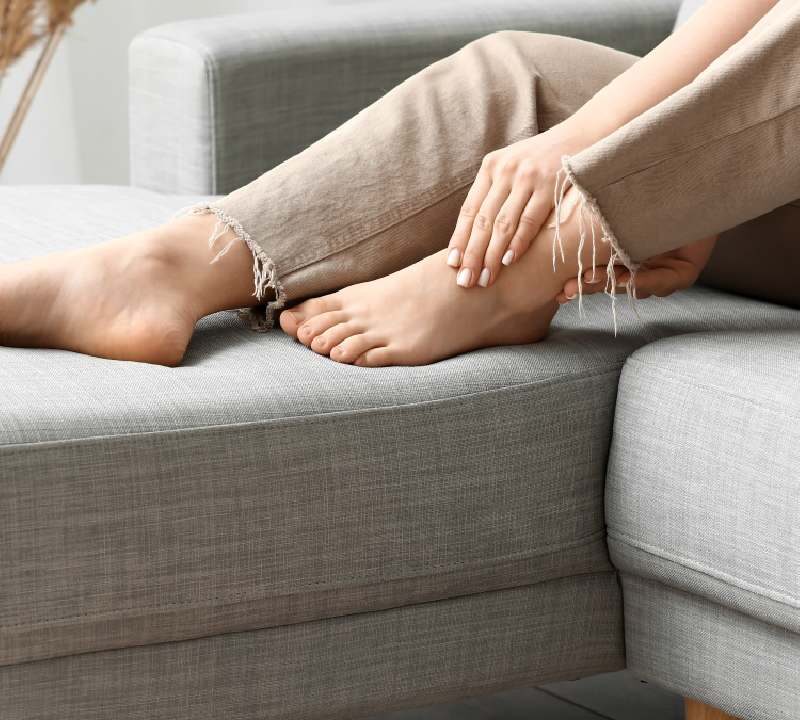 Persona con piernas cansadas y elevadas para mejorar la circulación sanguínea