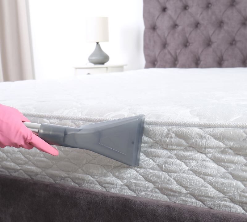 Alt text imagen: Persona aspirando un colchón para eliminar polvo y ácaros