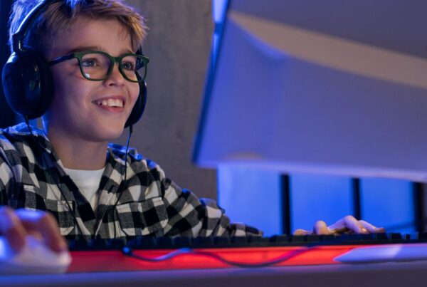 Un adolescente concentrado jugando a un videojuego en su habitación, ilustrando el riesgo de la transición de videojuegos y juegos de azar.