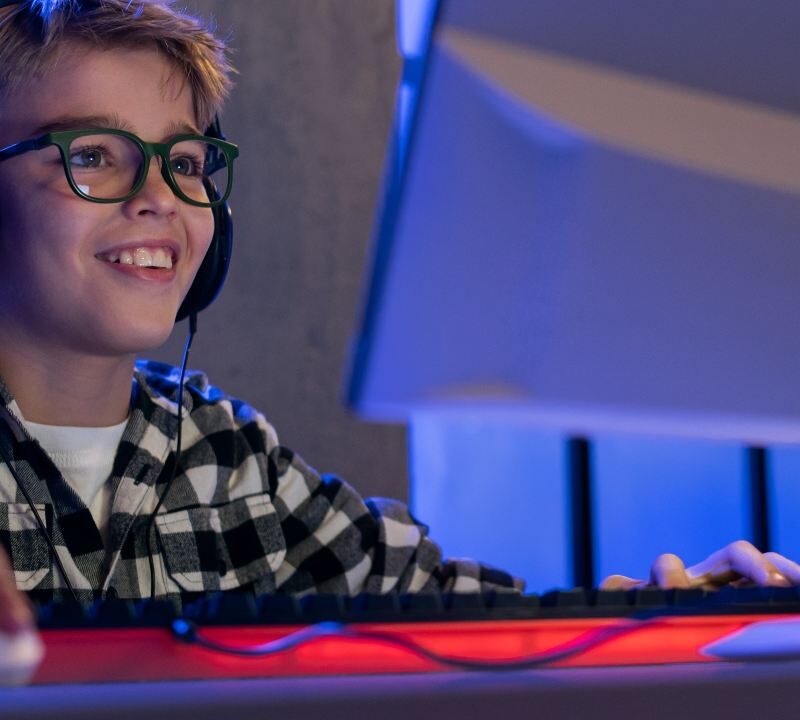 Un adolescente concentrado jugando a un videojuego en su habitación, ilustrando el riesgo de la transición de videojuegos y juegos de azar.