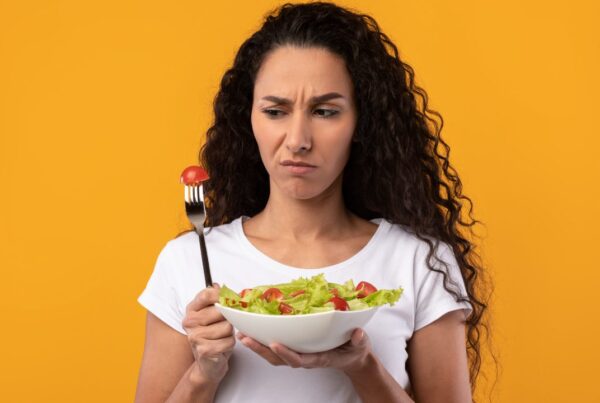 Persona cansada mirando plato pequeño durante dieta