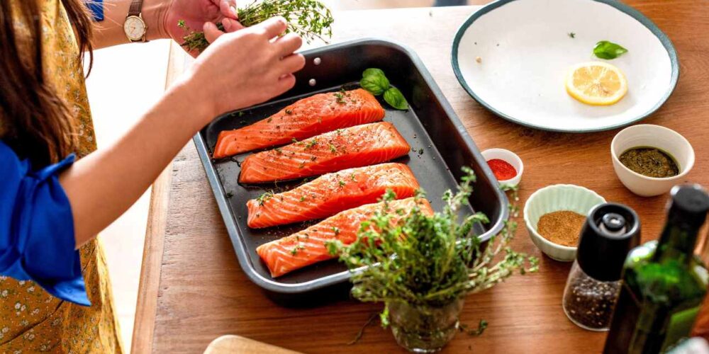 Persona cocinando con hierbas frescas y especias como alternativa a la sal