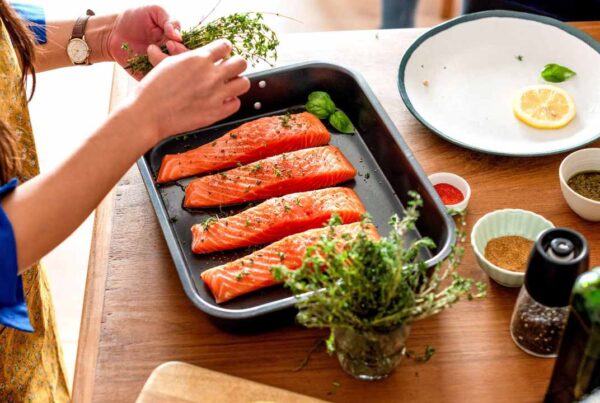 Persona cocinando con hierbas frescas y especias como alternativa a la sal