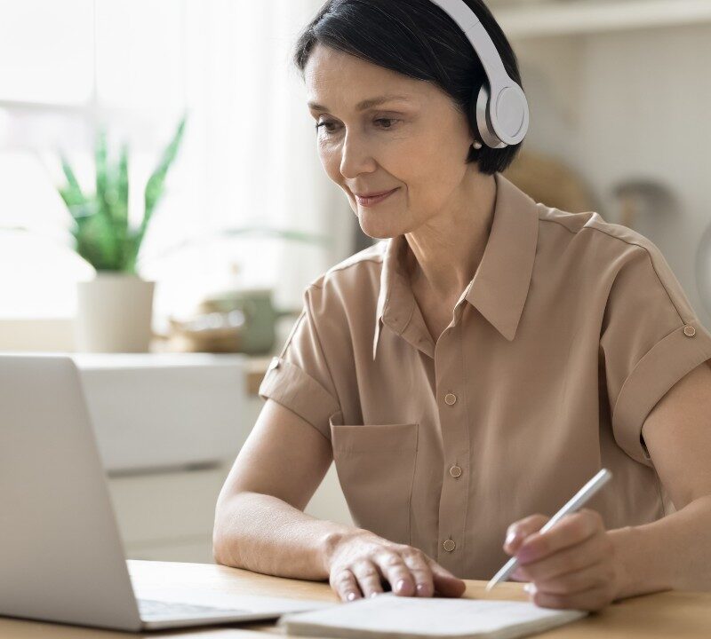 Persona adulta estudiando un nuevo idioma con libros y aplicación móvil, mostrando aprendizaje a cualquier edad