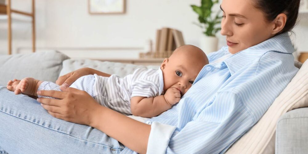 Madre en posparto descansando con su bebé en un entorno tranquilo