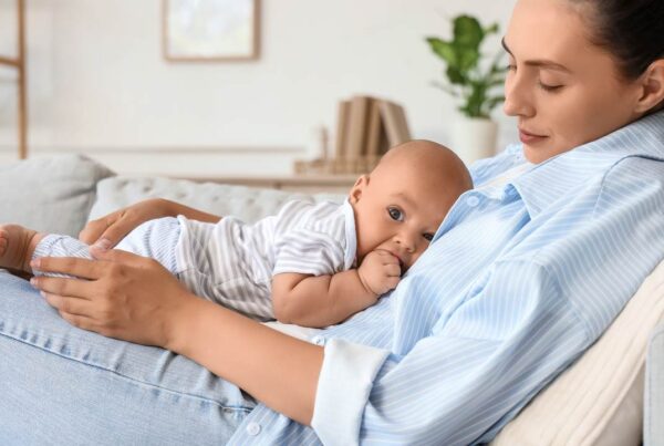 Madre en posparto descansando con su bebé en un entorno tranquilo