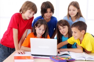 Schoolchildren using laptop computer.